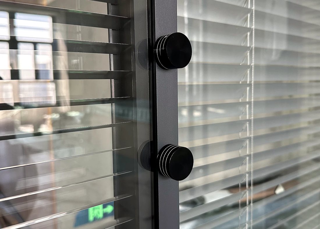 Detail of the tilting mechanism on a double-glazed partition with integrated blinds