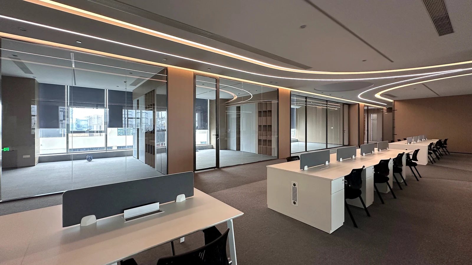 Open-plan office fitted with black-framed glass partitions and a glazed meeting room
